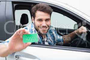 Young man smiling and holding card