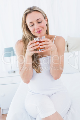 Cheerful blonde holding hot beverage