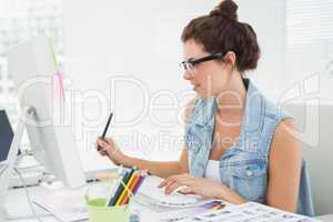 Cheerful casual businesswoman using computer and digitizer