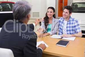 Salesman giving car keys to a couple