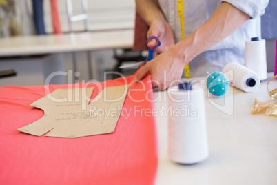 Student cutting fabric with pair of scissors