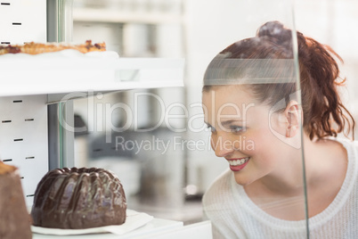 Pretty brunette looking at cake