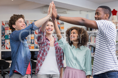 Fashion students high fiving together