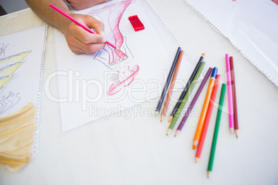 College student drawing picture with colored pencil