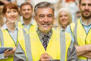 Warehouse team with arms crossed wearing yellow vest