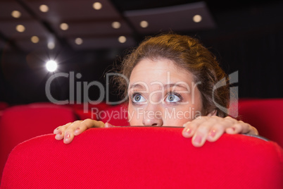 Young woman watching a scary film