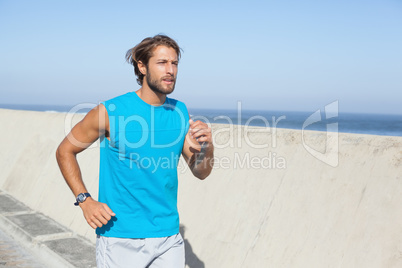 Fit man jogging on promenade