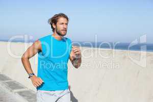 Fit man jogging on promenade