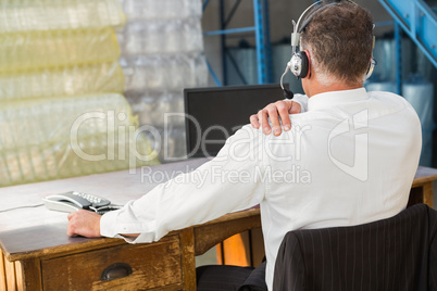 Rear view of warehouse manager using computer