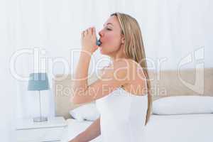 Pretty blonde using asthma inhaler