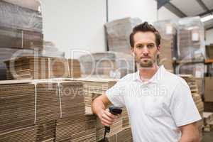 Serious warehouse worker holding scanner