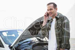 Smiling man calling for assistance after breaking down