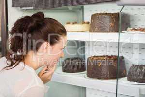 Pretty brunette looking at cake