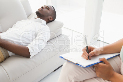 Man lying on sofa talking to his therapist