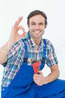 Plumber holding monkey wrench while gesturing OK sign