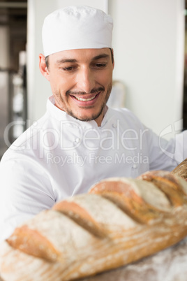Happy baker taking out fresh loaf