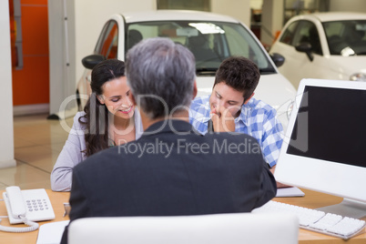 Smiling couple signing a contract