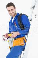 Happy construction worker leaning on ladder