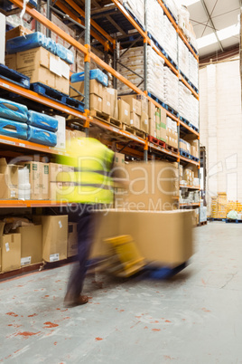 Worker pushing trolley with boxes in a blur