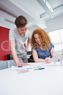 Smiling students working and taking notes together