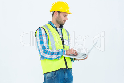 Repairman in reflective workwear using laptop