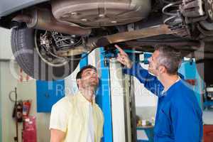 Mechanic showing customer the problem with car