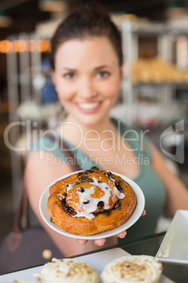 Pretty brunette showing a pastry