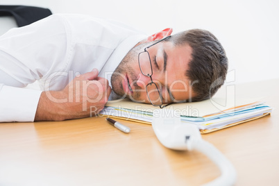 Exhausted businessman sleeping at his desk