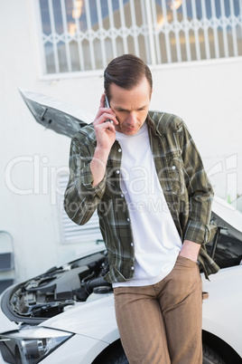 Unsmiling man calling for assistance after breaking down
