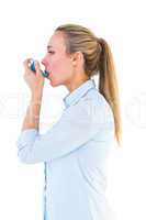 Beautiful blonde using an asthma inhaler