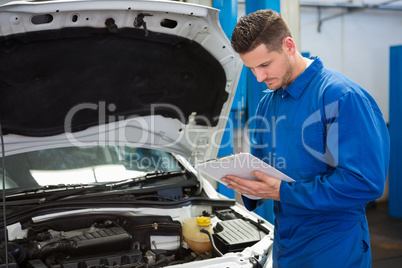 Mechanic writing on a clipboard