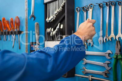 Mechanic taking a tool from wall