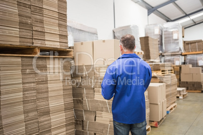 Warehouse worker checking his list on clipboard