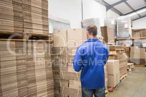 Warehouse worker checking his list on clipboard