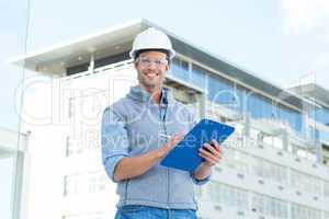 Happy male architect writing on clipboard