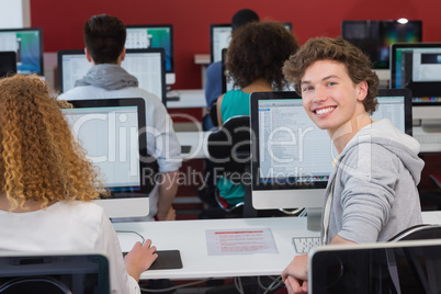 Student smiling at camera in computer class