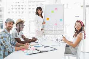 Smiling businessman and colleagues looking at camera