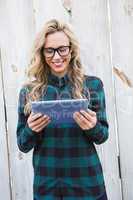 Cheerful blonde with glasses using tablet pc