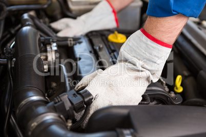 Mechanic examining under hood of car