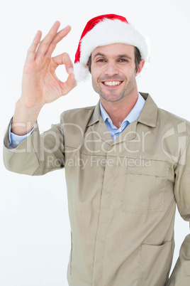 Delivery man in Santa hat gesturing OK sign