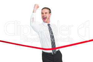 Businessman crossing the finish line while clenching fist