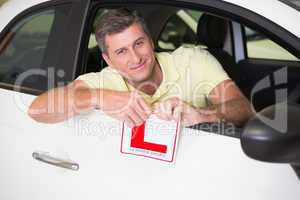 Cheerful male driver tearing up his L sign