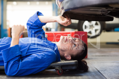 Mechanic lying and looking under car