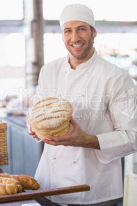 Happy baker with loaf of bread