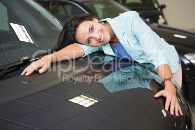 Smiling woman hugging a black car