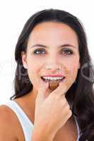 Pretty brunette eating chocolate candy