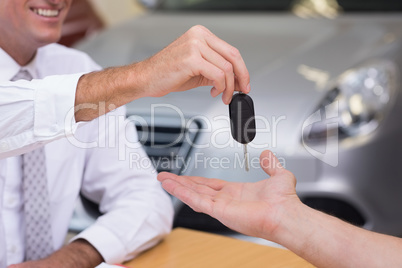 Salesman giving a customer car keys