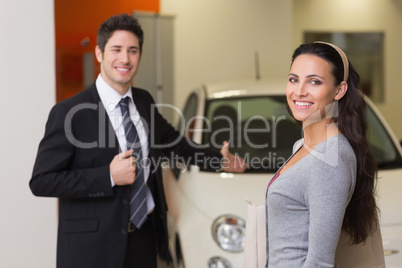 Businessman showing a car to a woman Businessman showing a car to a woman