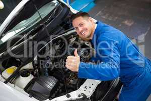 Mechanic examining under hood of car