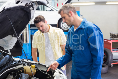 Mechanic showing customer the problem with car